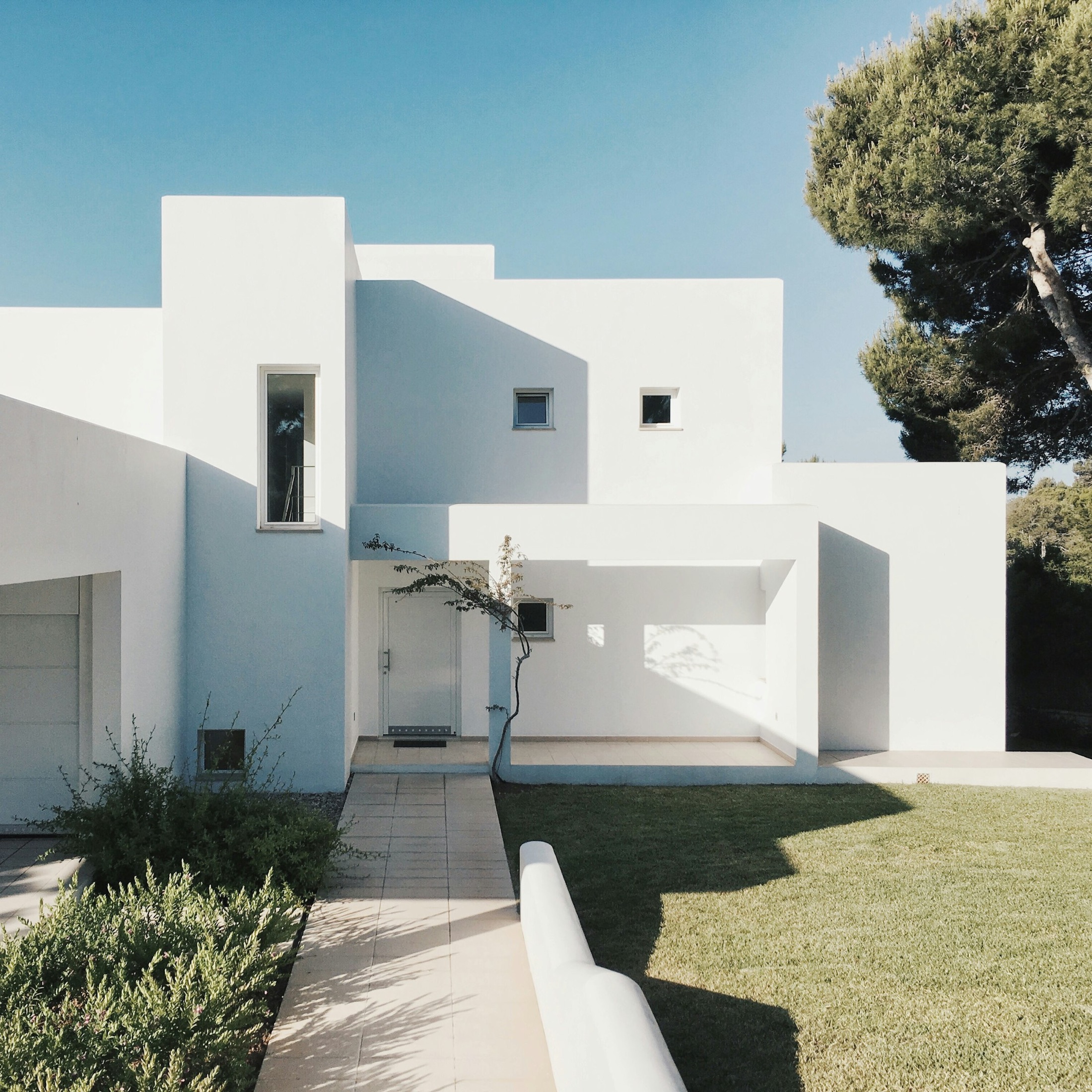 White modernist house with a landscaped garden path